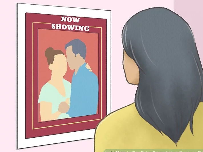 A woman looks at a picture of a married couple