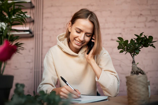 Woman writing in a journal with a smile