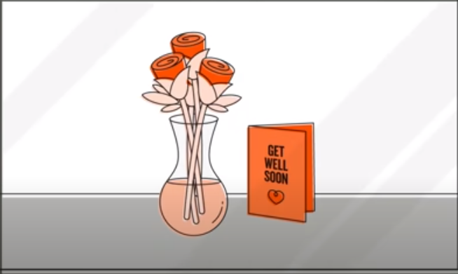 a transparent vase with a bouquet of flowers and a card next to it