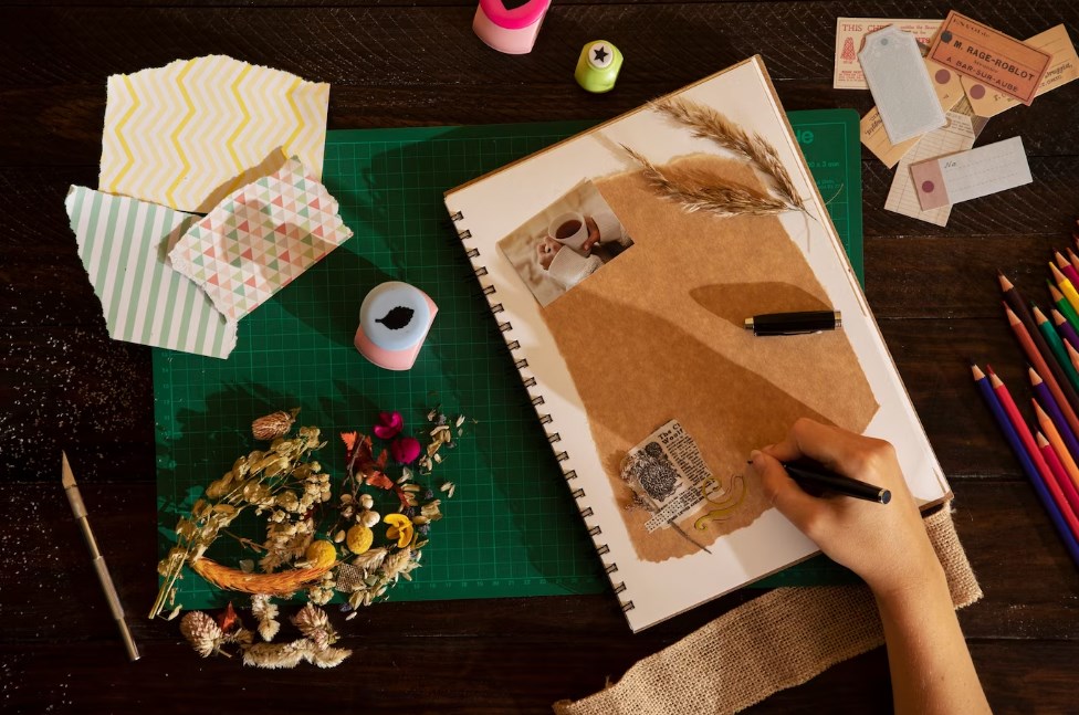 a hand of a person with a pen while scrapbooking at home