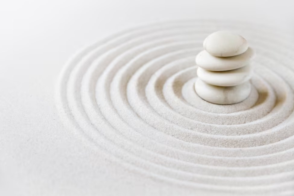 a Japanese dry garden with white circles of sand and four white stones
